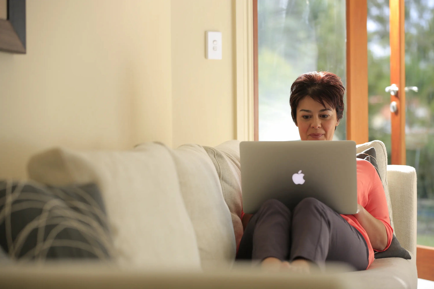Sitting in the sofa while checking on her laptop