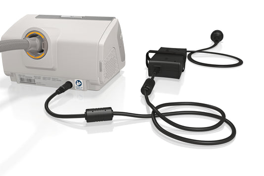 A black ResMed AirSense 10 Power Supply connected to a CPAP machine