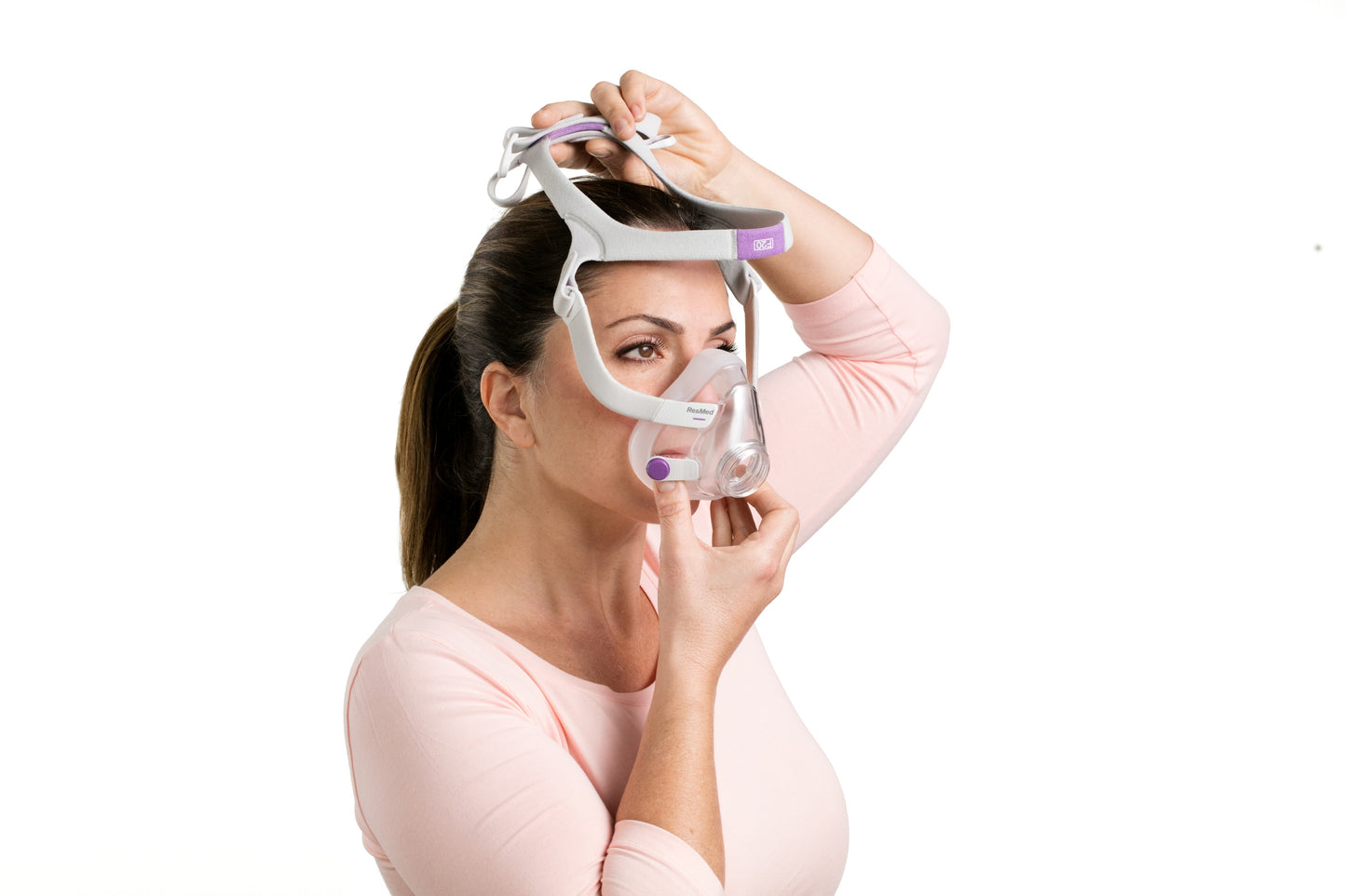 A woman trying on the Airfit F20 For Her Full Face CPAP Mask