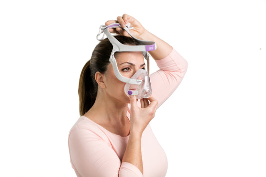 A woman trying on the Airfit F20 For Her Full Face CPAP Mask