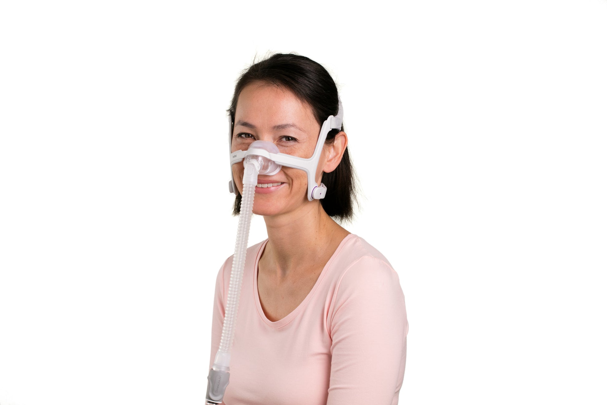 A woman smiling while wearing the ResMed AirFit N20 For Her Nasal CPAP Mask