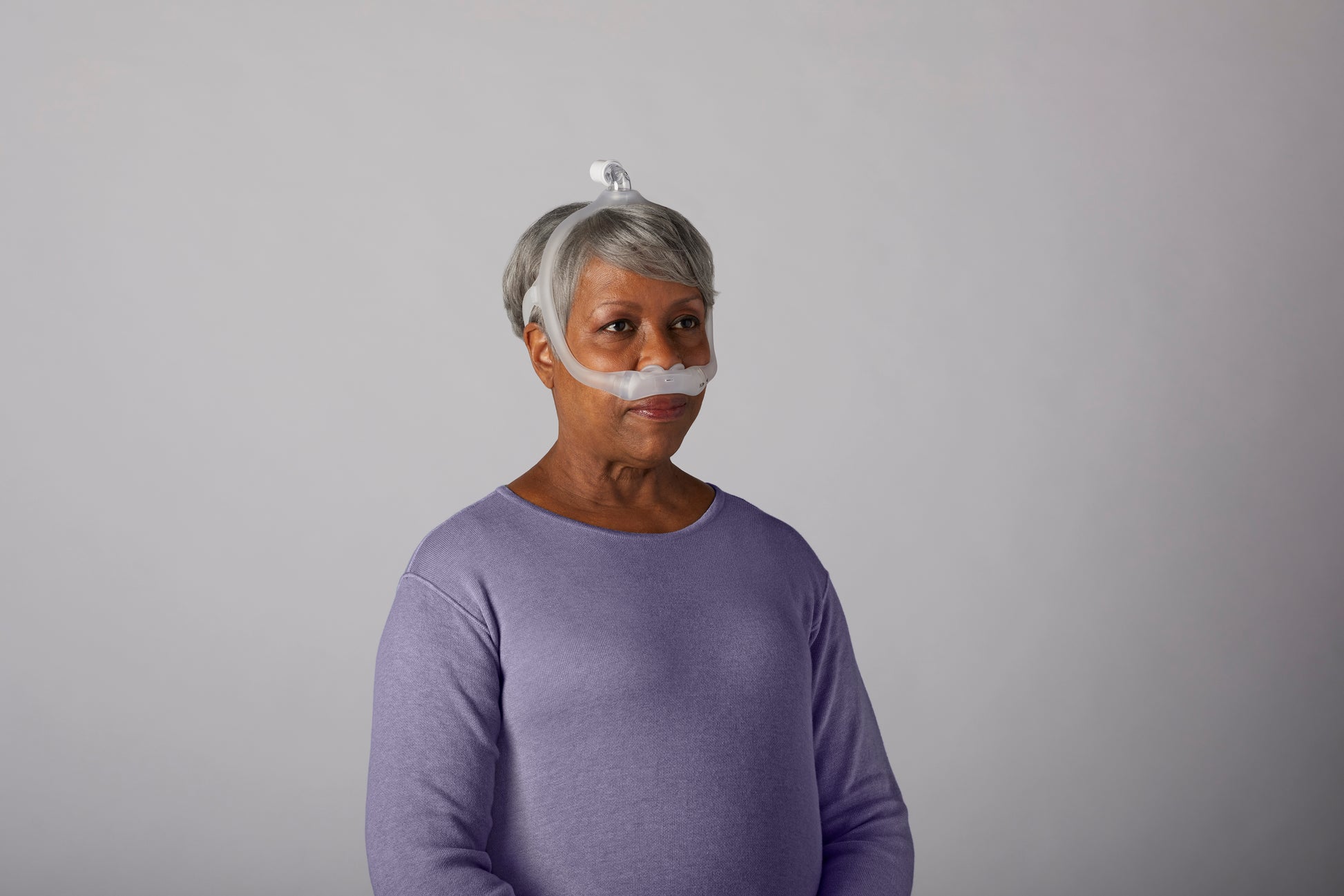 A woman wearing the DreamWear Nasal Pillow Mask