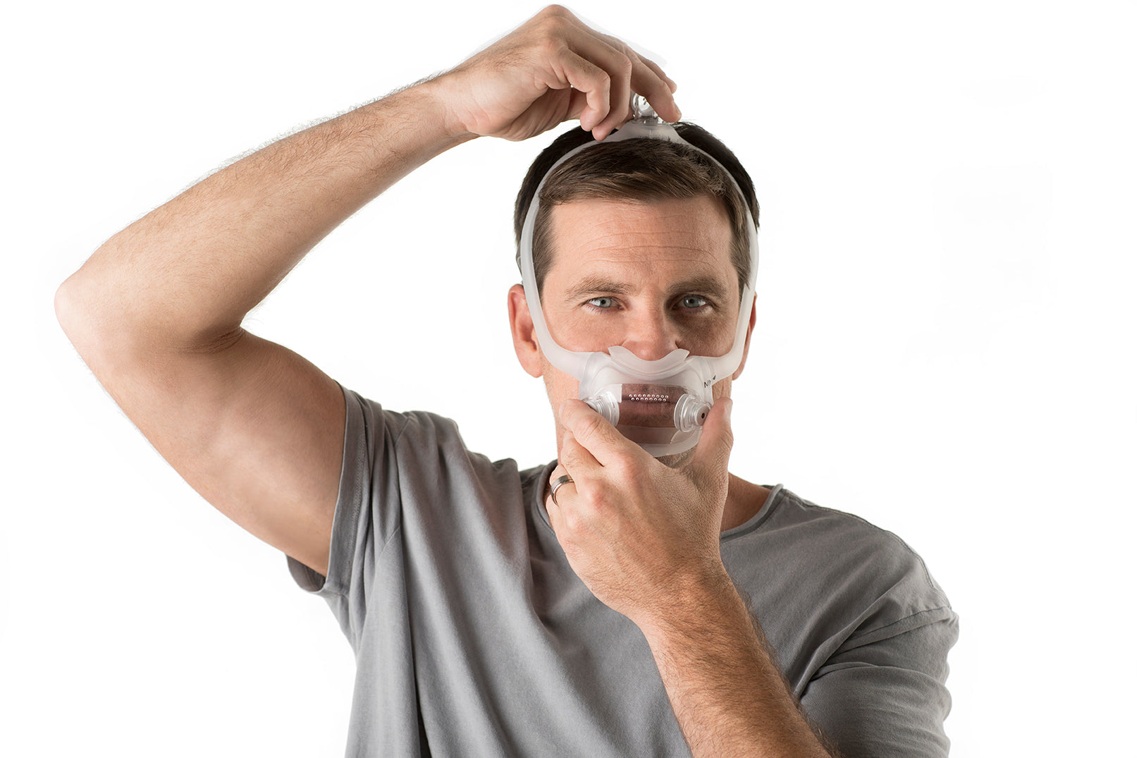 A man putting on the DreamWear Full Face CPAP Mask