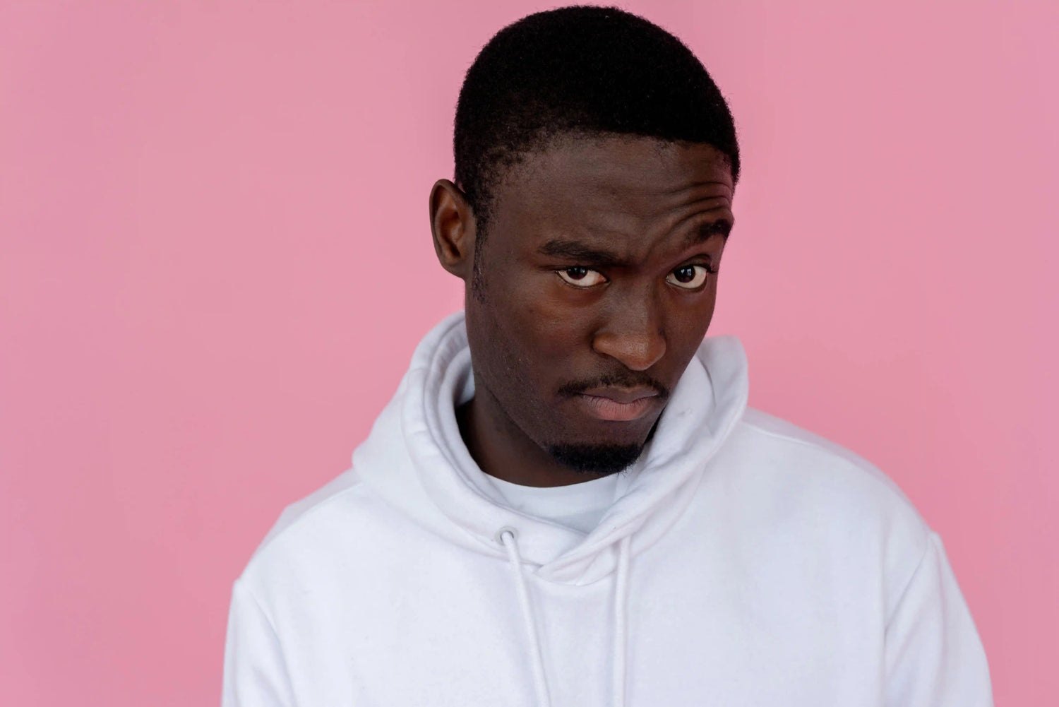 Uncertain black man in hoodie in studio