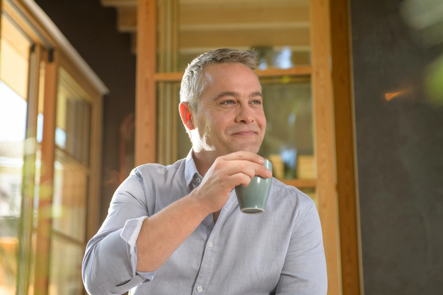 A man holding his mug and smiling 