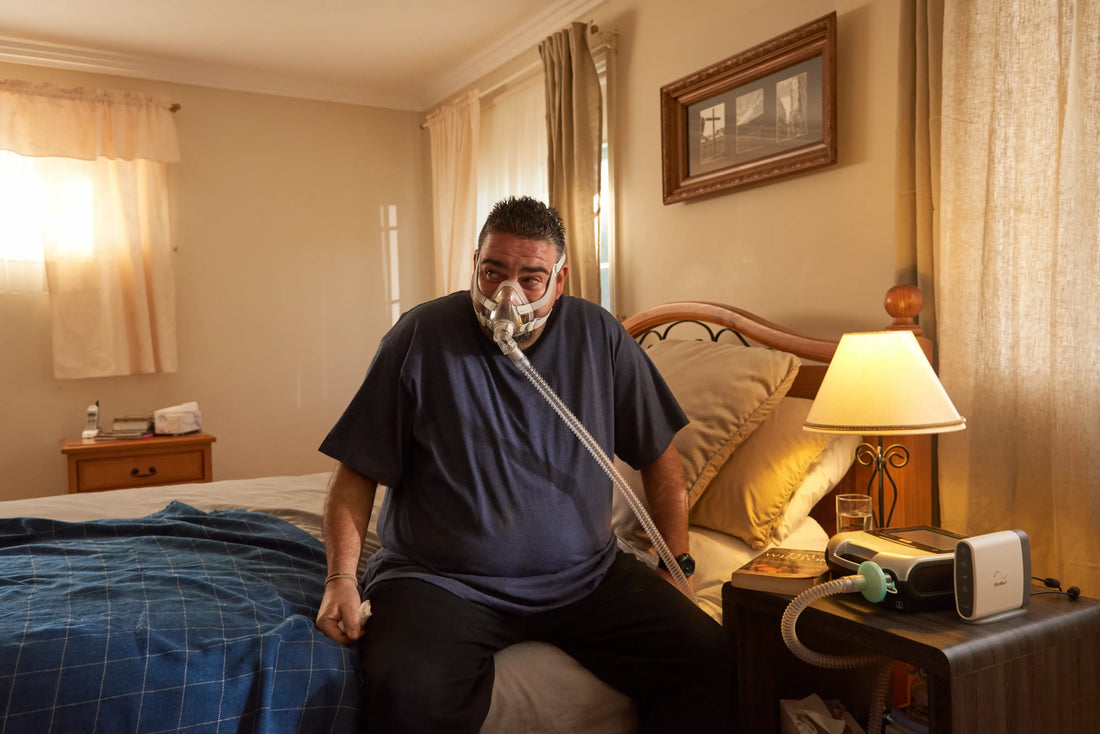 A man in a bedroom just sitting in bed while using cpap machine
