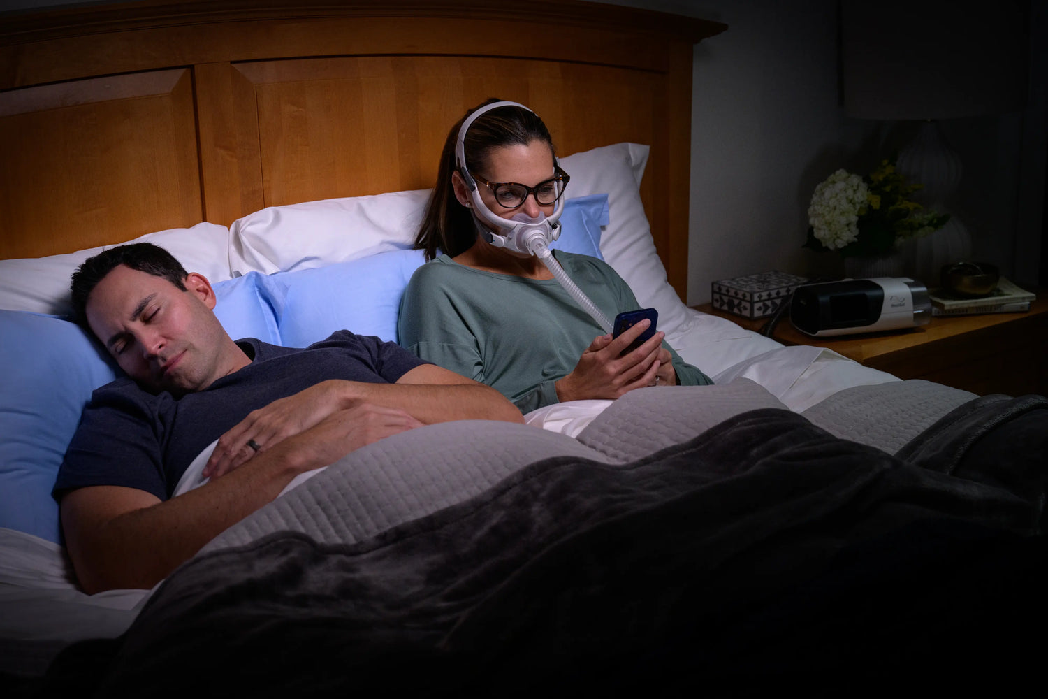 Woman looking at her phone while using cpap machine 