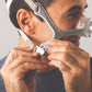 A man in the act of wearing the Wisp Nasal CPAP Mask