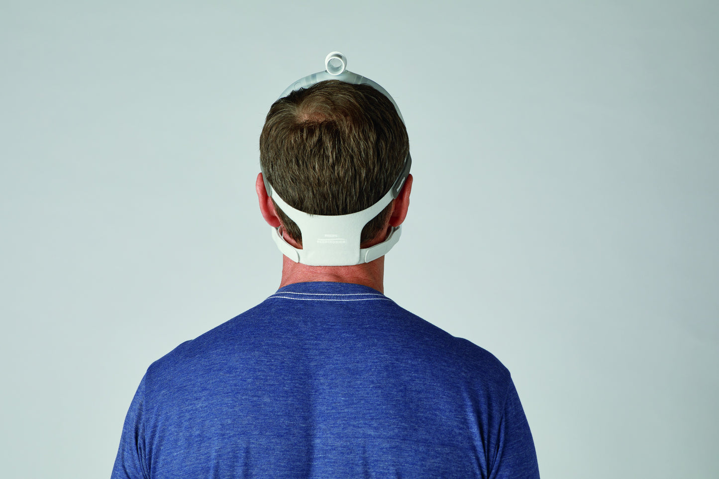 the back view of a man's head wearing a CPAP Mask